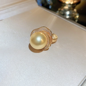 Vue macro détaillée d'une bague perle dorée avec accents de diamants pavés ondulés