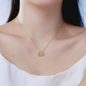Close-up of golden shell and starfish pendant with sparkling rhinestones on model neck