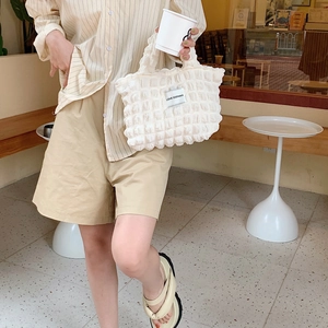 White bubble texture tote bag in a cozy outdoor cafe scene with a modern lazy style