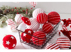 Close-up of red and white Christmas ornaments with candy and mushroom shapes in a basket
