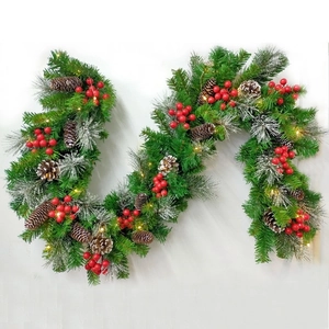 Close-up of Christmas rattan with red berries, pine cones and warm LED string lights