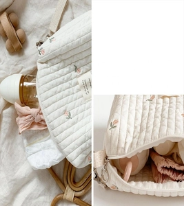 Close-up of quilted baby organizer bag showing tulip embroidery and spacious interior