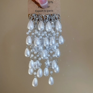 Detailed macro view of silver tassel earrings with tiered water-drop faux pearls