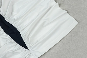 Gros plan des coutures contrastées et de l'ourlet élastique de la robe tricotée