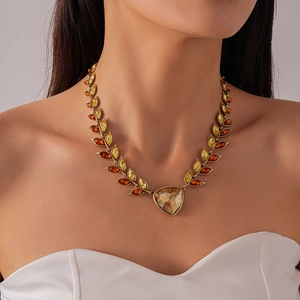 Macro detail of vintage gold necklace with amber crystal wheat leaves and large pendant