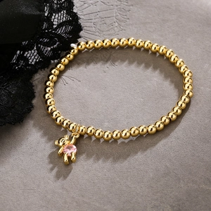 Gold beaded bracelet with cute teddy bear charm featuring a pink heart-shaped zircon