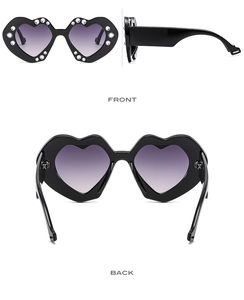 Detail view of heart-shaped sunglasses featuring purple gradient lenses and crystal rhinestones