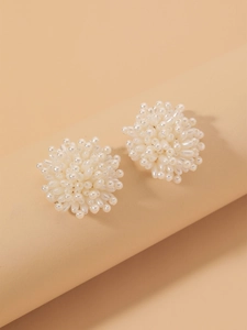 Detailed close-up of white cluster beaded flower earrings with high-gloss pearl finish