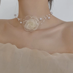 Macro detail of elegant mesh rose flower and white pearls on chic choker necklace
