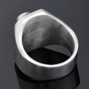 Macro detail of silver punk skull ring showing brushed stainless steel texture