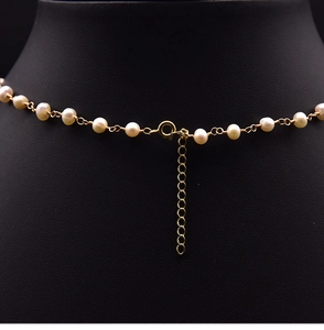 Macro detail of natural freshwater pearl necklace with gold-plated clasp and adjustable chain
