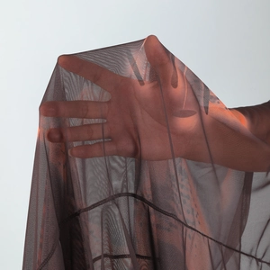 Close-up of brown breathable sheer mesh fabric texture with elastic fine net detail