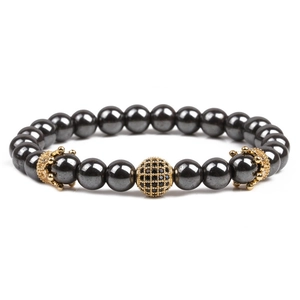 Detailed macro of hematite stone bead bracelet with gold crown and zircon accents
