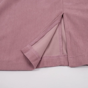 Macro detail of dusty pink corduroy dress hemline with side slit and fine stitching