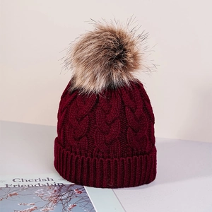 Winter cable knit beanie for kids in dark red with a fluffy faux fur pom-pom topper