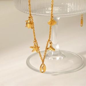 Detailed view of gold stainless steel necklace with starfish, turtle and shell pendants