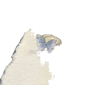 Elegant silver butterfly ring featuring gradient blue crystals on a textured band