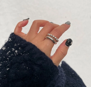 Close-up of minimalist 925 sterling silver beaded and smooth stackable rings on snow background