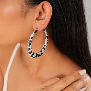 Close-up of stylish leopard print hoop earring worn by a model for a trendy fashion look