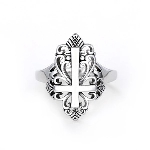 Vintage silver hollow ring with cross and scrolling vine patterns on a gray background