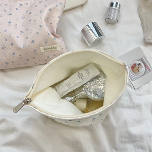 Close-up of floral makeup bags with cotton texture and organized skincare items