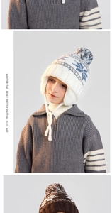 Close-up of kids winter knit hat featuring blue snowflake patterns and soft pom-pom detail