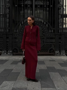 Detail of burgundy knitted set showing buttoned cardigan and matching long skirt