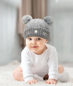 Detailed knit texture and soft faux fur pom-poms on a grey baby cat beanie hat