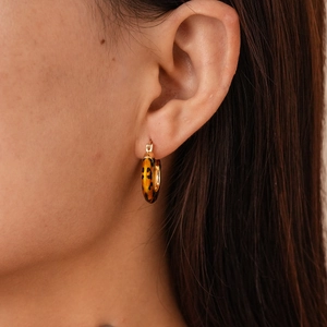 Close-up of 14k gold plated leopard print hoop earrings on model with retro style