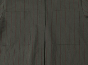Detail of dark grey striped shirt showing vertical red lines and dual chest pockets