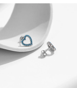 Vue macro de boucles d'oreilles cœur en argent S925 avec perles turquoise et fermoirs papillon