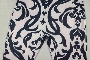 Detailed view of the baroque scroll print pattern on these sleeveless high neck jumpsuits