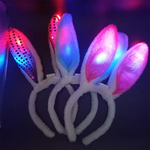 LED plush rabbit ear headbands with glowing pink and blue lights in a dark background
