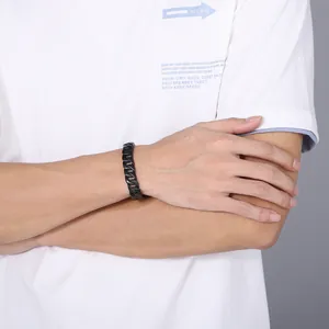Nahaufnahme eines minimalistischen schwarzen Titanstahl-Panzerarmbands am Handgelenk eines Models
