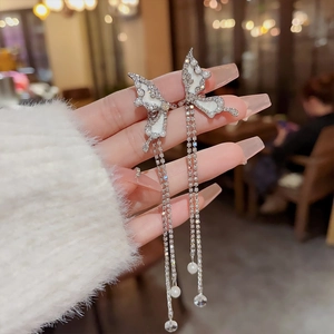 Detailed close-up of butterfly tassel earrings with crystals and pearl drops