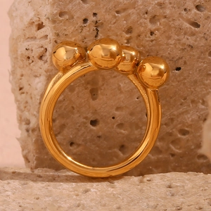 Detail shot of a creative 18K gold-plated ring featuring unique circular floral accents