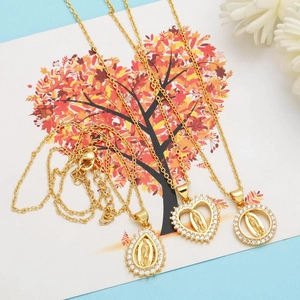 Detailed view of three gold pendants with Virgin Mary relief and crystal borders