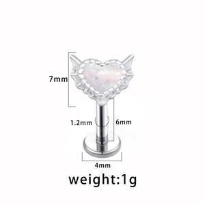 Macro view of heart-shaped labret stud with wing design and specific size measurements