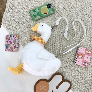 Cute white plush goose crossbody bag with yellow beak and orange plaid scarf on a rug