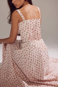 Detail of the backless floral midi dress featuring slim straps and a pink flower print