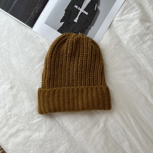 Close-up of caramel ribbed knit beanie featuring thick texture and wide folded cuff