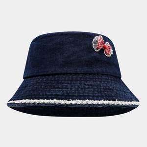 Detail of dark blue denim kids bucket hat featuring white lace trim and checkered bow tie