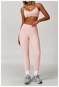 Pink high-waist yoga leggings and sports bra set showing fabric texture and stretch fit