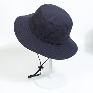 Detail view of dark blue outdoor sun hat with adjustable chin strap and toggle on stand