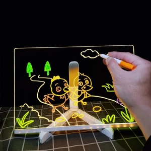 Macro shot of hand drawing on luminous acrylic board with glowing fluorescent pens