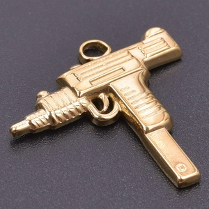 Macro shot of 18k gold plated stainless steel Uzi gun pendant with polished finish