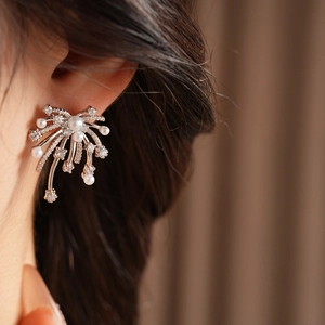 Close-up of model wearing silver zircon firework earrings with white pearls