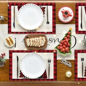 Close-up of red and black buffalo plaid Christmas placemats with festive tree patterns