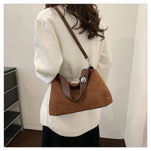 Vue détaillée d'un sac oreiller en daim marron avec boucle argentée et poignée en cuir