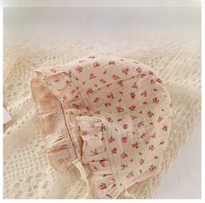 Detailed view of pink floral baby sun hat with ruffled brim and woven tie straps